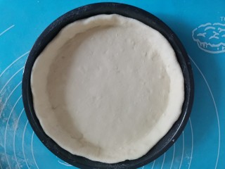 5、奶香红薯披萨,发酵好后取出来揉面排气，擀成圆形薄饼放入披萨烤盘，边缘用手压一压