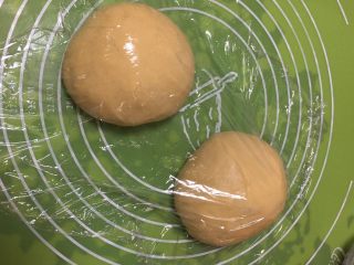 14、面包蛋糕混合包,面团分成两个剂子，整理滚圆，盖上保鲜膜静置10分钟。