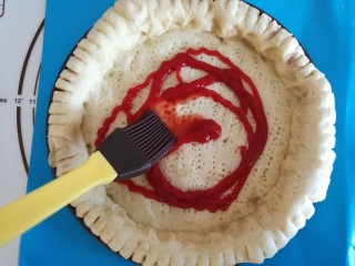 11、圣女果披萨,烤好的披萨胚拿出来，首先刷上番茄酱