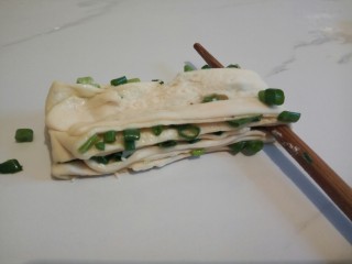 11、#咸味#快速发酵的花卷,再将面团慢慢拉长，筷子放在中间