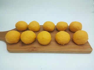 9、最爱面包+奶香南瓜面包棒,将发酵好的面团放在案板上，排出面团内部的气体，分成10小份，盖上保鲜膜醒发15分钟