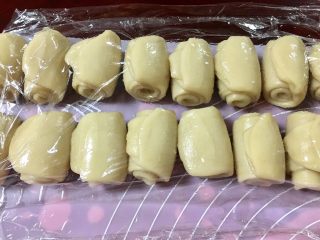 14、馅中馅蛋黄酥(肉松麻薯豆沙蛋黄),从一头卷起,保鲜膜盖好,醒十五分钟。