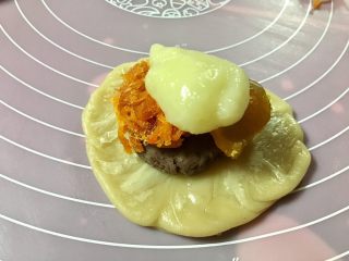 16、馅中馅蛋黄酥(肉松麻薯豆沙蛋黄),放上一份麻薯,肉松,豆沙馅,咸蛋黄,不规则的放入就行,包好,用手的虎口处收口,烤箱预热170度。