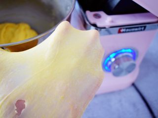 5、南瓜吐司,继续启动厨师机揉面,直到揉出手膜,即是可以拉出薄薄的一层薄即可