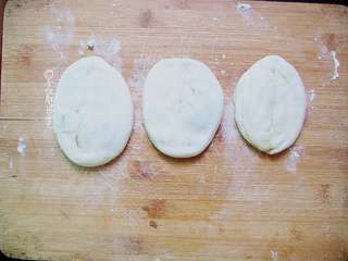 6、十味 芝麻酱烧饼,将面团竖着放在操作台上,用手压扁,擀成椭圆形