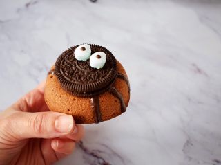 12、万圣节甜甜圈蜘蛛蛋糕,把奥利奥饼干沾住，再用黑色巧克力笔画出蜘蛛脚，晾干即可