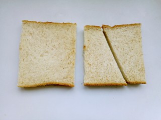 1、吐司披萨,将吐司片两边边切掉，然后在对角切开成两半。