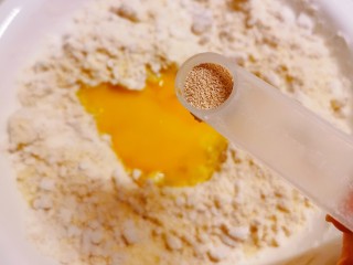 5、炸油饼,敲入鸡蛋  放入酵母 小苏打 盐  