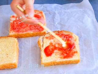 2、吐司披萨,吐司上抹一层番茄酱。如果有披萨酱就抹披萨酱。