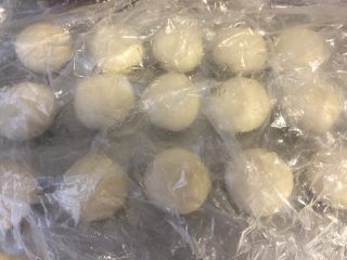 4、美味肉松酥,将一个油皮用手按扁，包入一个油酥，收好收口滚圆，依次完成所有，操作的时候将面团都盖上保鲜膜。