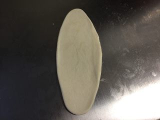 5、美味肉松酥,将小面团按扁，檊成长舌状。