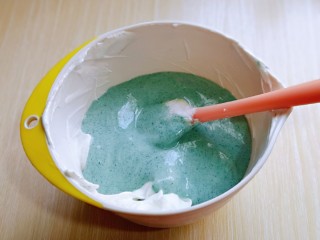 14、6寸蝶豆花戚风蛋糕,最后将蛋黄糊倒入蛋白霜的容器中,继续翻拌手法,直至看不到蛋白霜即可。