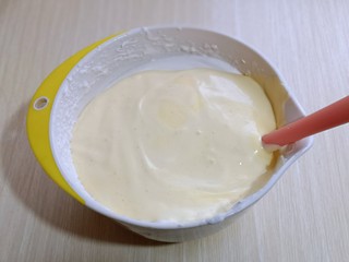 12、超ins卡通蛋糕 让小朋友幸福感爆棚,最后将蛋黄糊倒入蛋白霜的容器中，继续翻拌的手法，直至看不到蛋白霜即可。