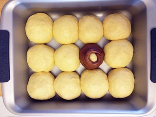 6、维尼熊跳跳虎挤挤小面包,将薄片环起,包住圆球,做成蜂蜜罐的样子。其他面团揉成球,放入模具中