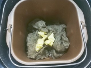 5、红糖黑芝麻叶子软欧,加入软化的黄油，继续揉面至完全扩展阶段；