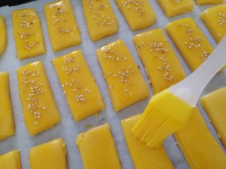 13、炉果,放在烤盘上,刷蛋黄液,洒上白芝麻。