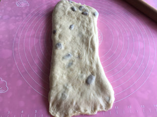 10、面包机版果干燕麦吐司,将折好的面团坚过来擀长,底部按薄。