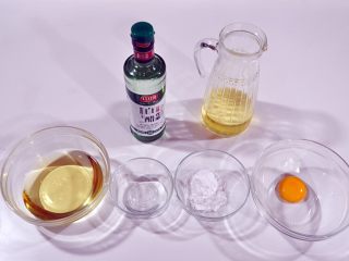 1、自制沙拉酱,将所需要的原料：蛋黄、糖粉、白醋、植物油分类装在碗里。