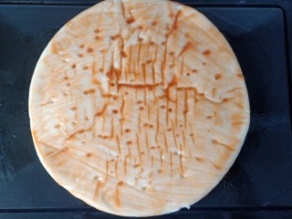 8、培根芝士披萨,在面饼上刷上一层均匀的番茄酱。