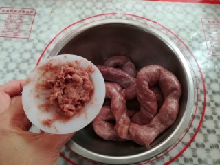8、自制脆皮肠,把肉沫从漏斗口用筷子缓慢的灌到肠衣里，别把肠衣弄破了