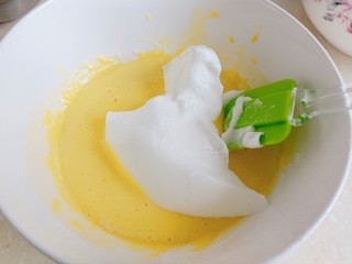 9、草莓酸奶蒸蛋糕,倒入三分之一打发好的蛋白至蛋黄液中，切拌均匀。