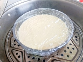 12、草莓酸奶蒸蛋糕,纸倒入模具中震荡几下把大气泡震出，盖上保鲜膜。