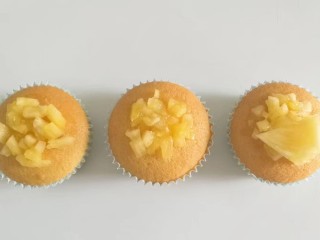 12、果味长崎纸杯蛋糕,最后把凤梨果肉丁和果肉片取适量放在蛋糕上，摆上薄荷叶装饰即成！