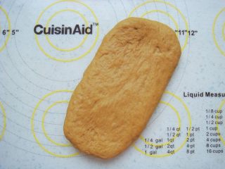 8、葡萄干红糖软欧,取一份面团轻轻的擀成长条状。(不要太用力,避免把面团里的空气擀跑掉)