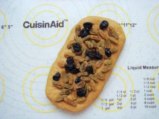 9、葡萄干红糖软欧,铺上一层葡萄干,轻轻的按几下。