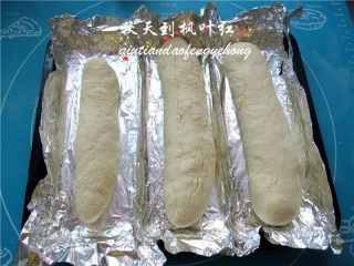 24、法棍面包,在烤盘里放上锡纸折叠起来作为墙壁,将整形好的法棍面包坯放入;