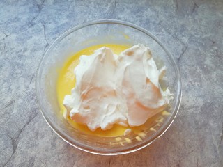 12、6寸中空戚风蛋糕,打发好的蛋白分成三份，取中间的三分之一加入到蛋黄糊里面，用硅胶刮刀采用切拌和翻拌的方法混合均匀。