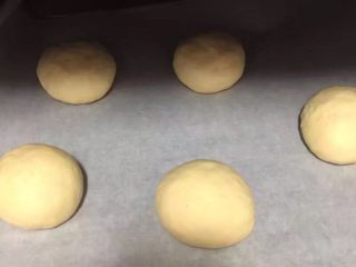 7、自制麦辣鸡腿汉堡,5个剂子揉至光滑，放入烤盘，如果不是不沾盘烤盘就铺上一张油纸，如图