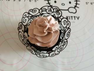 14、女巫杯子蛋糕,晾凉的蛋糕放到黑色纸托中,上边挤打发的巧克力奶油!最后在奶油上摆上女巫的帽子即可