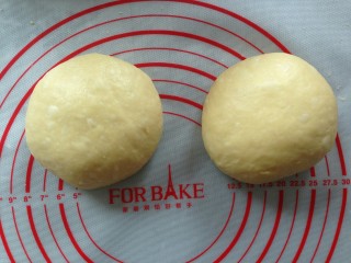 7、面包机版鸡蛋吐司,面团排气，分成两等份，滚圆，盖上保鲜膜，松弛20分钟