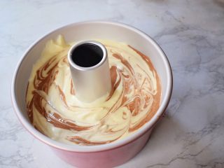 14、7寸中空双色戚风蛋糕,再用牙签来回划几下，端起模具的两端，轻轻震几下，震出大气泡