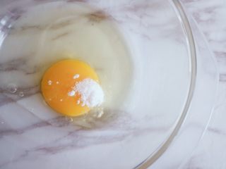 2、奶香浓郁的苹果千层派,将鸡蛋磕开加入白糖