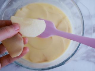 11、奶香浓郁的苹果千层派,我们将刚搅拌好的面糊慢慢放入苹果片，将苹果均匀的沾上面糊，最好一片一片沾以免有的沾不到，提前给烤箱预热，上下火200度