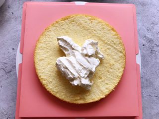 6、白雪公主蛋糕,取一片蛋糕片放在蛋糕拖上,然后放上适量的淡奶油