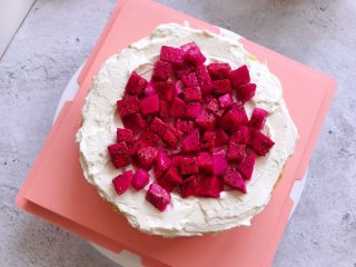 9、白雪公主蛋糕,用抹刀把淡奶油抹平,上面铺上一层红心火龙果