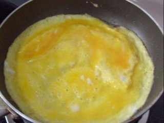 5、火腿肉松三明治,蛋液表面凝结时，鸡蛋饼翻个面，再煎1分钟即可盛出；