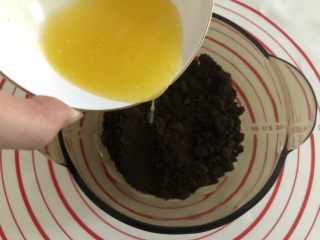 14、胜过冰淇淋蛋糕的「奥利奥冻芝士蛋糕」,这个时候黄油差不多已经融化好了,将融化的黄油倒入180g饼干碎里,搅拌均匀。