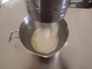 2、圣诞玛德琳,低筋面粉和泡打粉混合后筛入蛋盆。