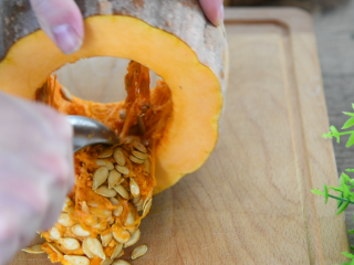 1、南瓜饼超详细的步骤来袭,在家轻松搞定!,用勺子刮去南瓜籽,使其表面光滑