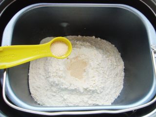 2、火龙果软欧包,面粉中间挖小坑倒入酵母粉盖上，一角处倒入盐。（避免酵母粉与盐直接接触影响活性）