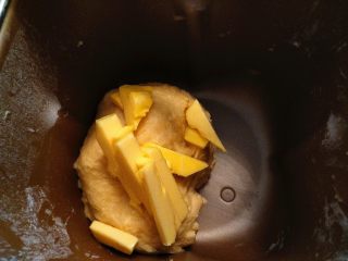 5、全蛋吐司,把黄油放在室温软化，改刀成小块。和面20分钟后，放入黄油。再和面30分钟。