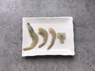 7、凤尾虾球,把虾去头,留尾部,把虾壳去掉留虾尾一节虾壳即可、用刀在虾尾中间划出大约2厘米距离,划到底,虾尾从切口处穿过去(如果你觉得麻烦就省略最后一步,个人觉得这样做出的虾球更好看,虾尾翻转一下虾尾更漂亮)