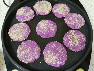 14、紫薯芝麻饼,电饼铛预热，刷上一层食用油，放入做好的紫薯芝麻饼。