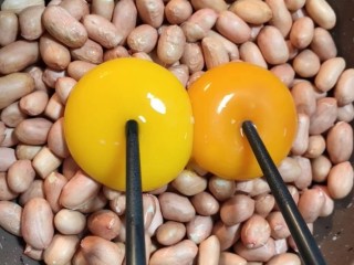 1、糖霜花生米,准备花生打入两个鸡蛋黄搅拌均匀
