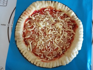 12、圣女果披萨,再铺上一层火腿肠,撒上马苏里拉芝士