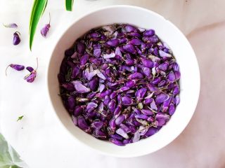 2、藤萝花饼,吃下整个春天,准备好所有的食材。藤萝花清洗两遍后,放入淡盐水中,浸泡15分钟,在用清水冲洗干净。浸泡的目的是让花里面的一些杂质或者小虫子,能全部出来。